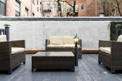 a patio with wicker chairs and a table and a couch at 26-3A STUDIO Gramercy W D Outdoor Courtyard in New York