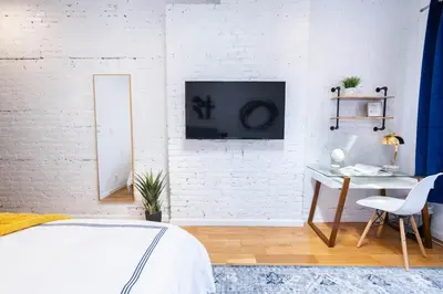 a bedroom with a bed and a white wall at 26-4A New Studio prime 20's W D Shared Courtyard in New York