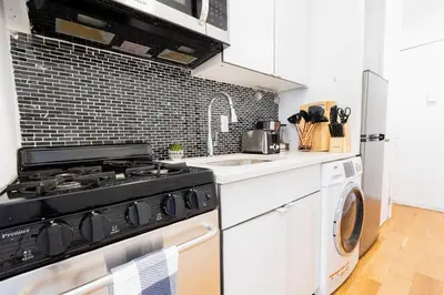 a kitchen with a stove and a washing machine at 26-4A New Studio prime 20's W D Shared Courtyard in New York