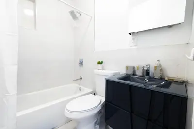 a white bathroom with a toilet and a sink at 26-4A New Studio prime 20's W D Shared Courtyard in New York