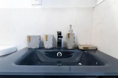 a bathroom sink with a faucet and toiletries on it at 26-4A New Studio prime 20's W D Shared Courtyard in New York