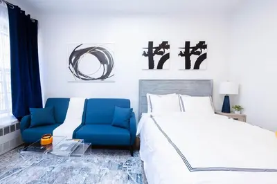 a bedroom with a bed and a blue chair at 26-4A New Studio prime 20's W D Shared Courtyard in New York