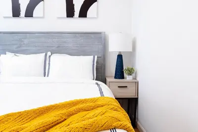 a bedroom with a bed with a yellow blanket on it at 26-4A New Studio prime 20's W D Shared Courtyard in New York