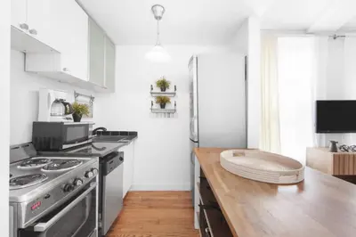 a kitchen with a stainless steel refrigerator and a wooden counter at 139-2E west village 1BR best value in New York