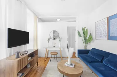 a living room with a blue couch and a table at 139-2E west village 1BR best value in New York