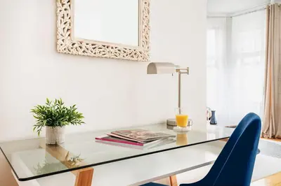 a glass table with blue chairs and a mirror at 139-2W Prime west village Furnished 2BR Best value in New York