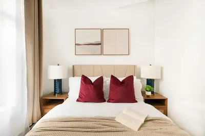 a bedroom with a bed with red pillows and two lamps at 139-2W Prime west village Furnished 2BR Best value in New York