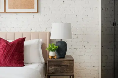 a lamp on a night stand next to a bed at 139-2W Prime west village Furnished 2BR Best value in New York