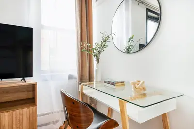 a glass desk with a mirror and a chair at 139-3E west village 1BR best value in New York