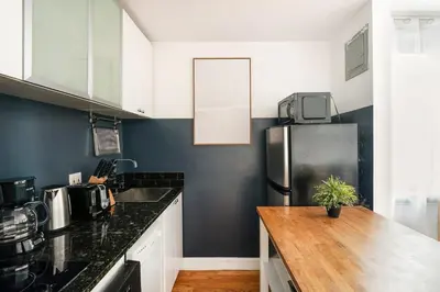 a kitchen with a refrigerator and a wooden counter top at 139-3E west village 1BR best value in New York
