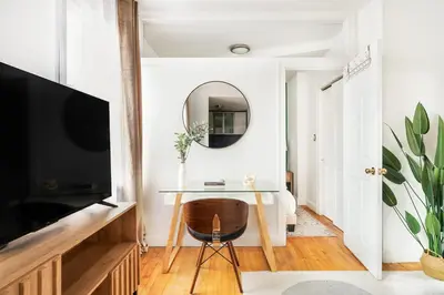 a living room with a table and a mirror at 139-3E west village 1BR best value in New York