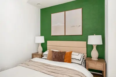 a bedroom with green walls and a bed with two lamps at 139-3E west village 1BR best value in New York