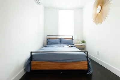 a bed in a white room with a window at 39-1 Renovated 3BR Prime Midtown West in New York