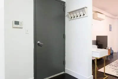 a glass shower door in a room with a desk at 39-1 Renovated 3BR Prime Midtown West in New York