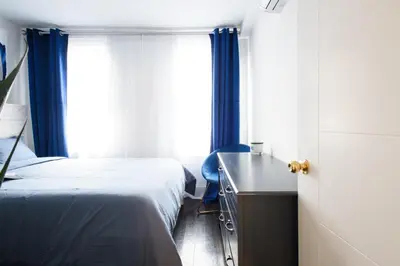 a bedroom with two beds and a desk and a window at 39-1 Renovated 3BR Prime Midtown West in New York
