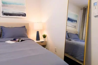 a bedroom with a mirror next to a bed at 39-1 Renovated 3BR Prime Midtown West in New York