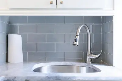 a sink in a kitchen with blue tiles at 39-3 Newly renovated 3 BR Prime midtown sleeps 6 in New York