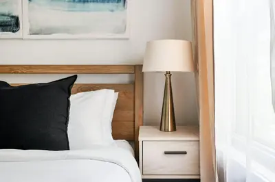 a bedroom with a bed with a lamp on a night stand at 39-3 Newly renovated 3 BR Prime midtown sleeps 6 in New York