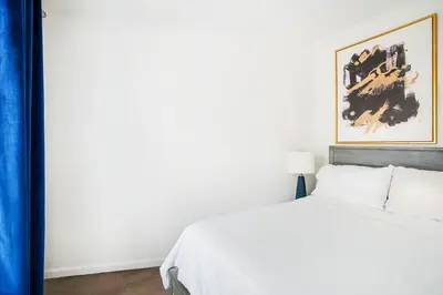 a bedroom with a white bed and a painting on the wall at 428-2E Newly furnished 2BR Prime Midtown sleeps 5 in New York