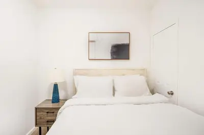a white bedroom with a bed and a table at 428-2E Newly furnished 2BR Prime Midtown sleeps 5 in New York