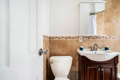 a bathroom with a toilet and a sink and a mirror at 428-2E Newly furnished 2BR Prime Midtown sleeps 5 in New York