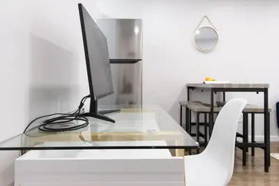 a glass desk with a computer monitor and a white chair at 350-2A Prime gramercy Newly renovated 1BR sleeps 4 in New York