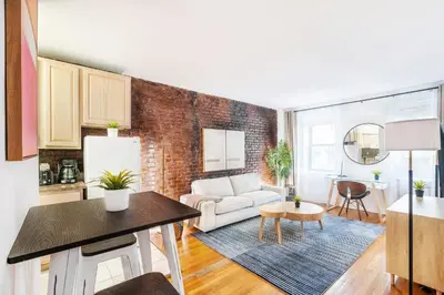 a living room with a white couch and a brick wall at 350-1A Gramercy New 1BR Sleeps4 Newly Furnished in New York
