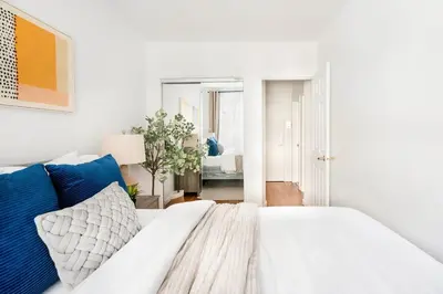 a white bed with blue pillows in a bedroom at 350-1A Gramercy New 1BR Sleeps4 Newly Furnished in New York