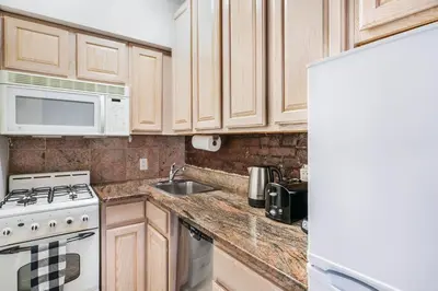 a kitchen with wooden cabinets and a stove and microwave at 350-1A Gramercy New 1BR Sleeps4 Newly Furnished in New York
