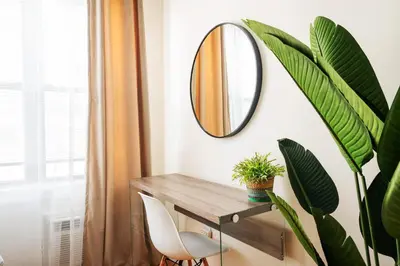 a mirror on a wall next to a table with a plant at 338-3B union square Newly Reno Sleeps 3 in New York