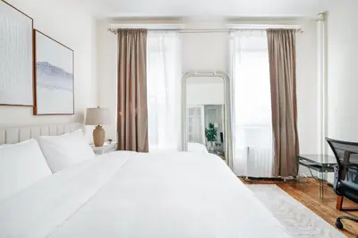 a bedroom with a large white bed and a mirror at 211-3 Prime Union Square Large 1BR Great value in New York