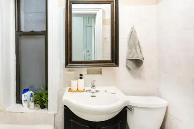a white bathroom with a sink and a mirror at 211-3 Prime Union Square Large 1BR Great value in New York