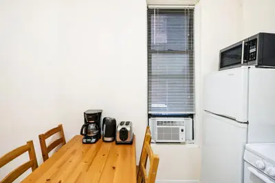 a kitchen with a wooden table and a refrigerator at 211-3 Prime Union Square Large 1BR Great value in New York