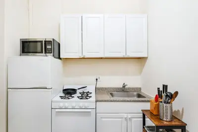 a white kitchen with a white refrigerator and a microwave at 211-3 Prime Union Square Large 1BR Great value in New York