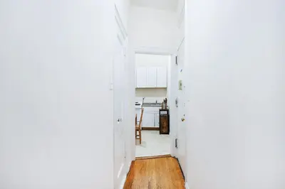 a hallway leading into a kitchen with white walls and wood floors at 211-3 Prime Union Square Large 1BR Great value in New York