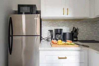 a kitchen with a refrigerator and a cutting board with fruit at 428-3R Spacious Prime Midtown 2BR Newly furnished in New York