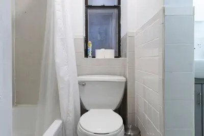 a white bathroom with a toilet and a shower at 428-3R Spacious Prime Midtown 2BR Newly furnished in New York