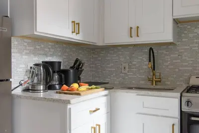 a kitchen with white cabinets and fruits on a cutting board at 428-3R Spacious Prime Midtown 2BR Newly furnished in New York
