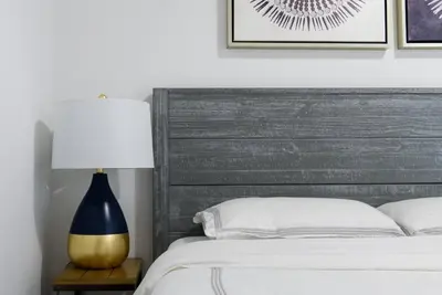 a bedroom with a bed with a gray headboard and a lamp at 428-3R Spacious Prime Midtown 2BR Newly furnished in New York