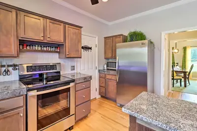 a kitchen with stainless steel appliances and wooden cabinets at Calm Columbia Haven Outdoor Pool, Hot Tub! in Delaware Water Gap