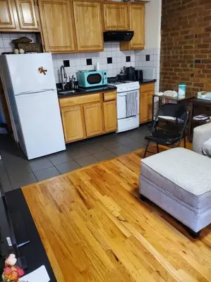 a kitchen with a white refrigerator and a wooden floor at In the heart of nyc! Time sq, theater district, javits center in New York