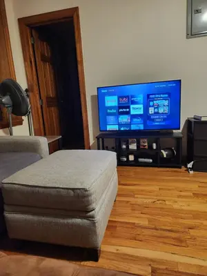 a living room with a flat screen tv and a chair at In the heart of nyc! Time sq, theater district, javits center in New York