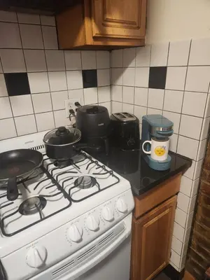 a kitchen with a stove with pots and pans on it at In the heart of nyc! Time sq, theater district, javits center in New York