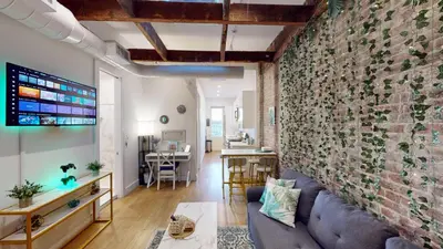 a living room with a brick wall and a couch at Chic Penthouse with bus stop at doorstep - 15 Minutes to NYC in Hoboken