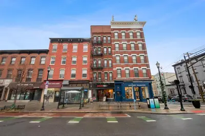 a large brick building on a city street at Chic Penthouse with bus stop at doorstep - 15 Minutes to NYC in Hoboken