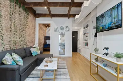a living room with a couch and a brick wall at Chic Penthouse with bus stop at doorstep - 15 Minutes to NYC in Hoboken