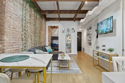 a living room with a brick wall and a table at Chic Penthouse with bus stop at doorstep - 15 Minutes to NYC in Hoboken