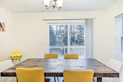 a dining room with a wooden table and yellow chairs at 3 Mi to Kalahari Pocono Summit Home with Game Room! in Pocono Summit