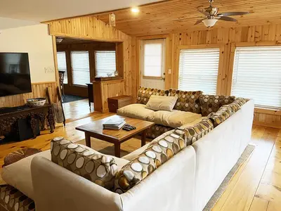 a living room with a large couch and a table at FRENCH WOODS FARMHOUSE Catskills Upper Delaware River Hancock NY in Hancock