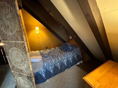 an attic bedroom with a bed in a room at Lakefront Cabin Pvt Beach and Dock - Sunset Marina in Arrowhead Lake